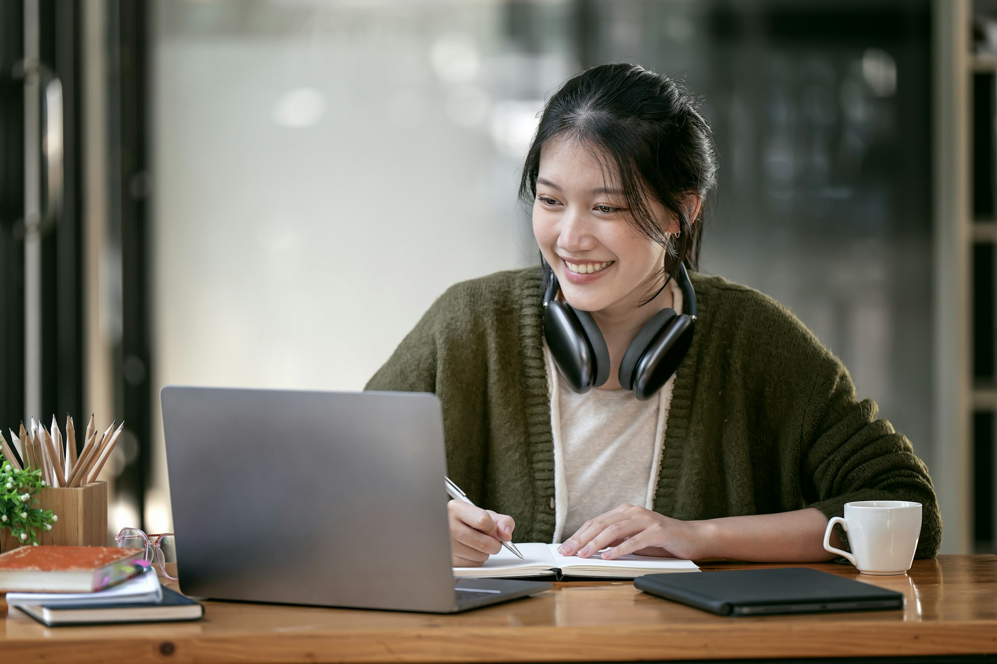 Portrait confident young female college student studying online via laptop computer